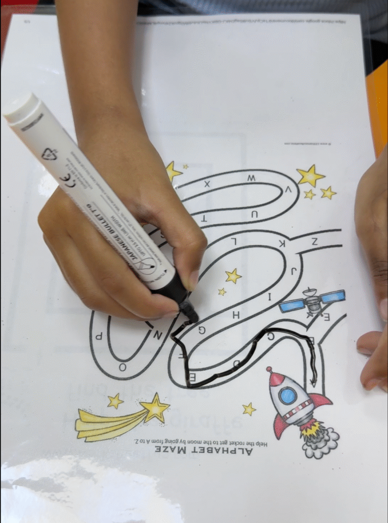 Child tracing an alphabet maze activity at the best special education center Dubai, developing fine motor and literacy skills.